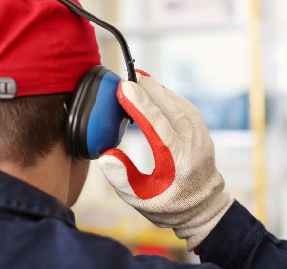 A Man Using Hearing Protection in a loud working environment